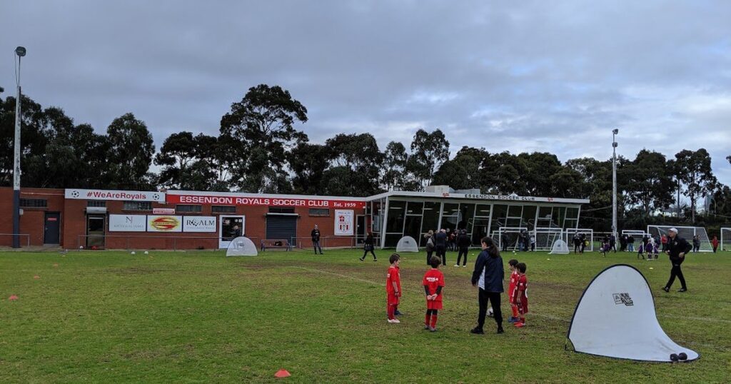 The Ormond Park pavilion, with Essendon Royals junior players training on the ground in front of it.